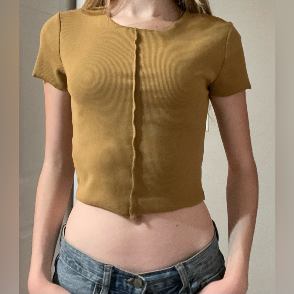 Mustard crop top with stiching in the middle.